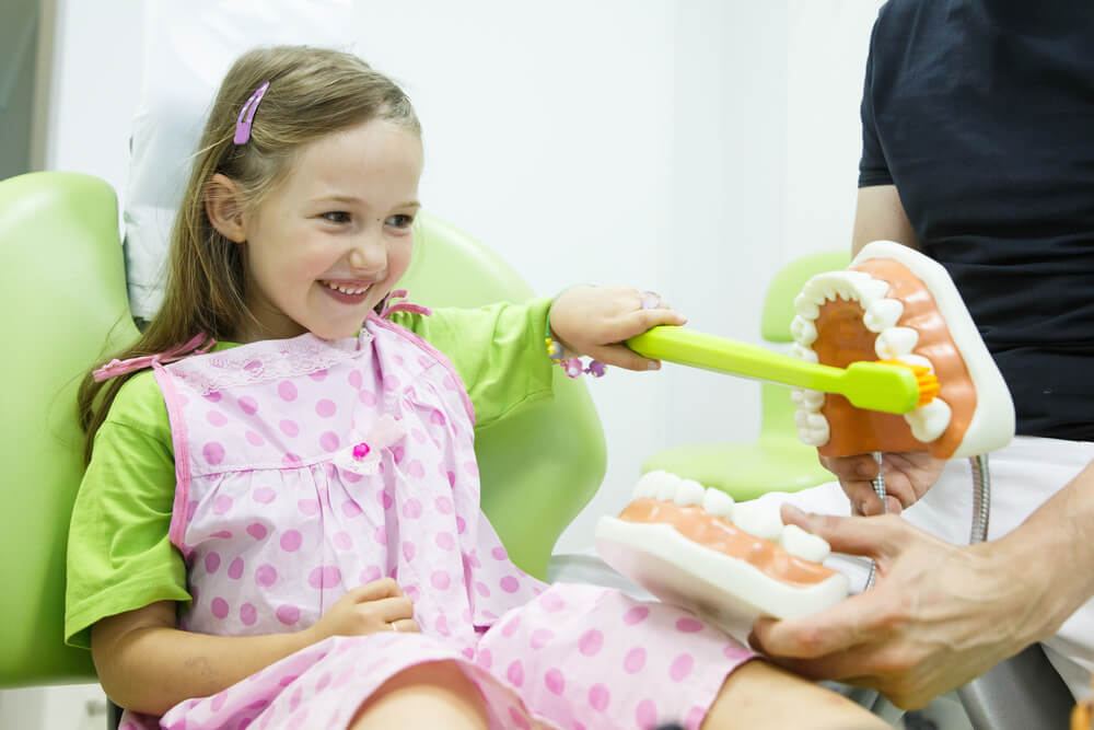 Smiling little girl in dentists chair,
